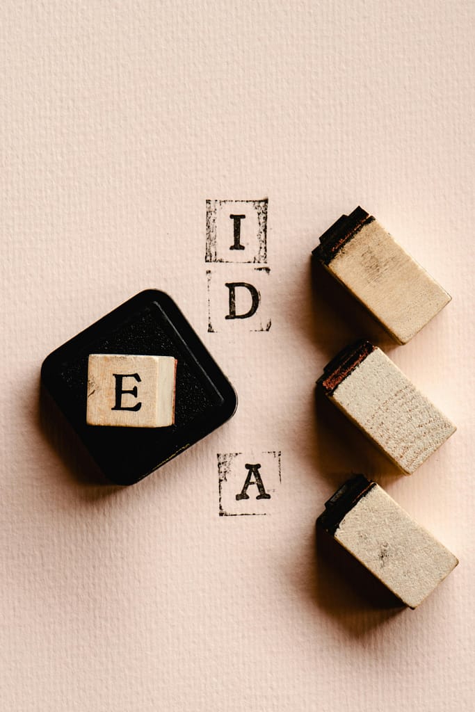 pexels-photo-6475525-6475525 Artistic arrangement of alphabet stamps forming the word 'IDEA' on paper.